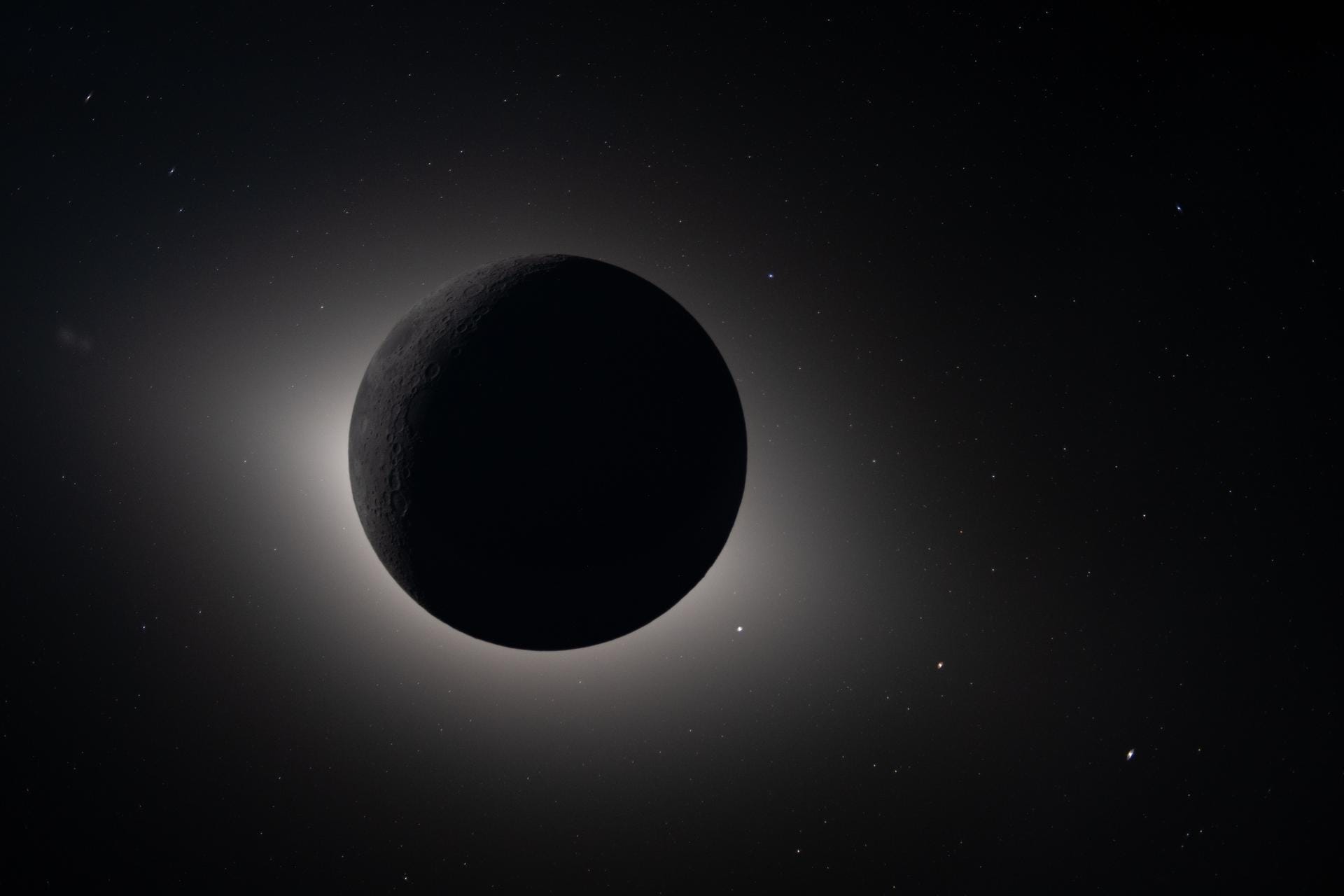 A photo taken during the Artemis II mission around the Moon, showing the dark side of the moon with an aura of sunlight around it