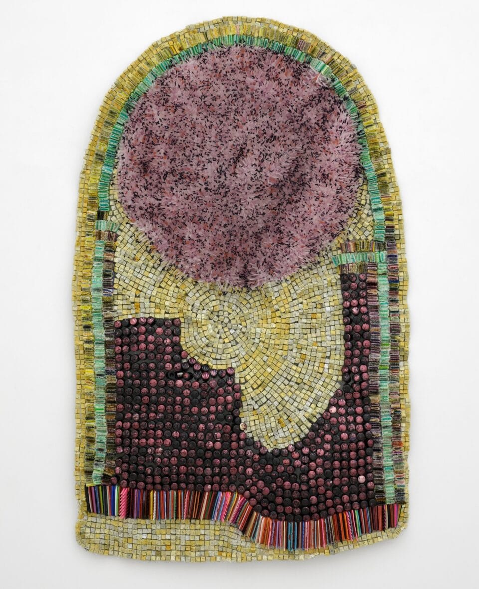 an abstract wall-installed artwork by Moffatt Takadiwa made from computer keyboard keys, combs, toothbrush heads, and pieces of nail polish applicators