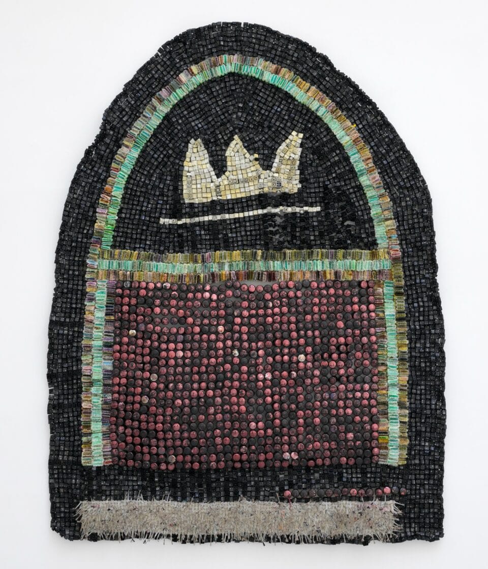 an abstract wall-installed artwork by Moffatt Takadiwa made from computer keyboard keys, combs, toothbrush heads, and pieces of nail polish applicators