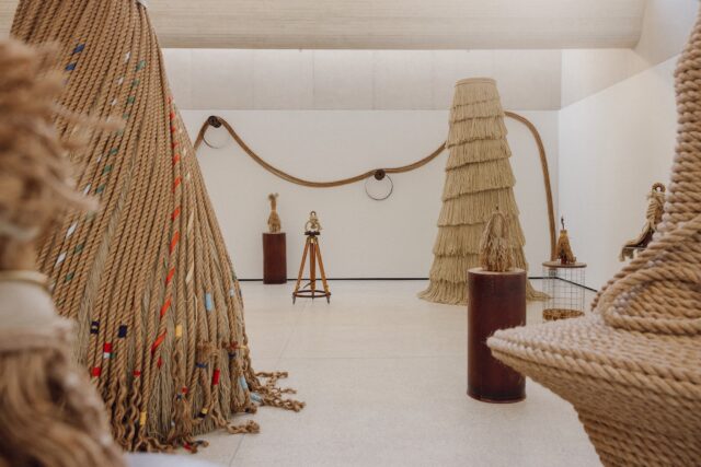 an installation view of LR Vandy's 'Rise' exhibition featuring abstract sculptures made of rope and wooden parts